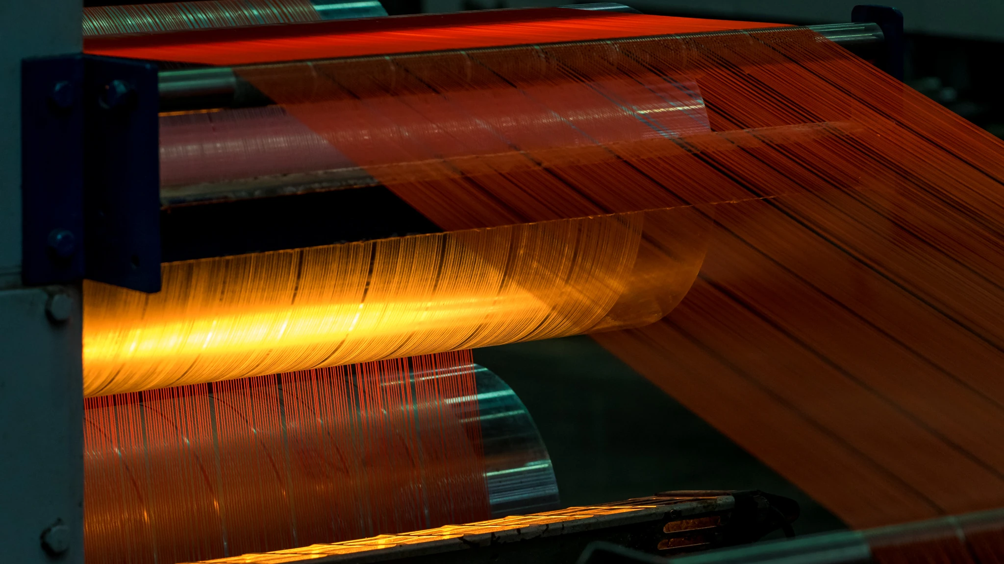 Cobalt technical shade textile moving through precision machinery